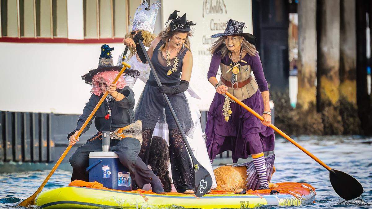 Four witches share one paddeboard at the ninth annual Morro Bay Witches Paddle on Saturday, Oct. 22, 2022.