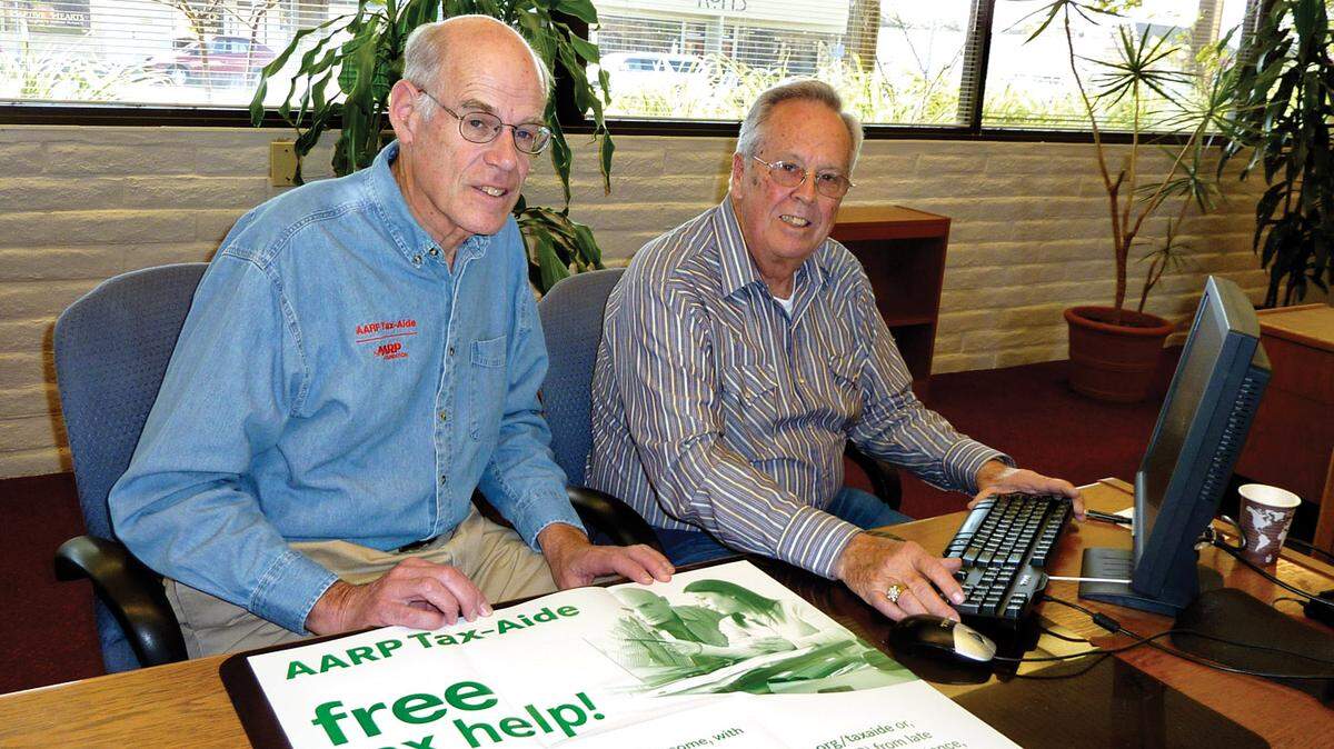 Jerry Winkenbach, left, and Don Gore in Grover Beach show the AARP Tax-Aide poster used to promote the service in 2012. The program is looking for volunteers to help people file taxes.