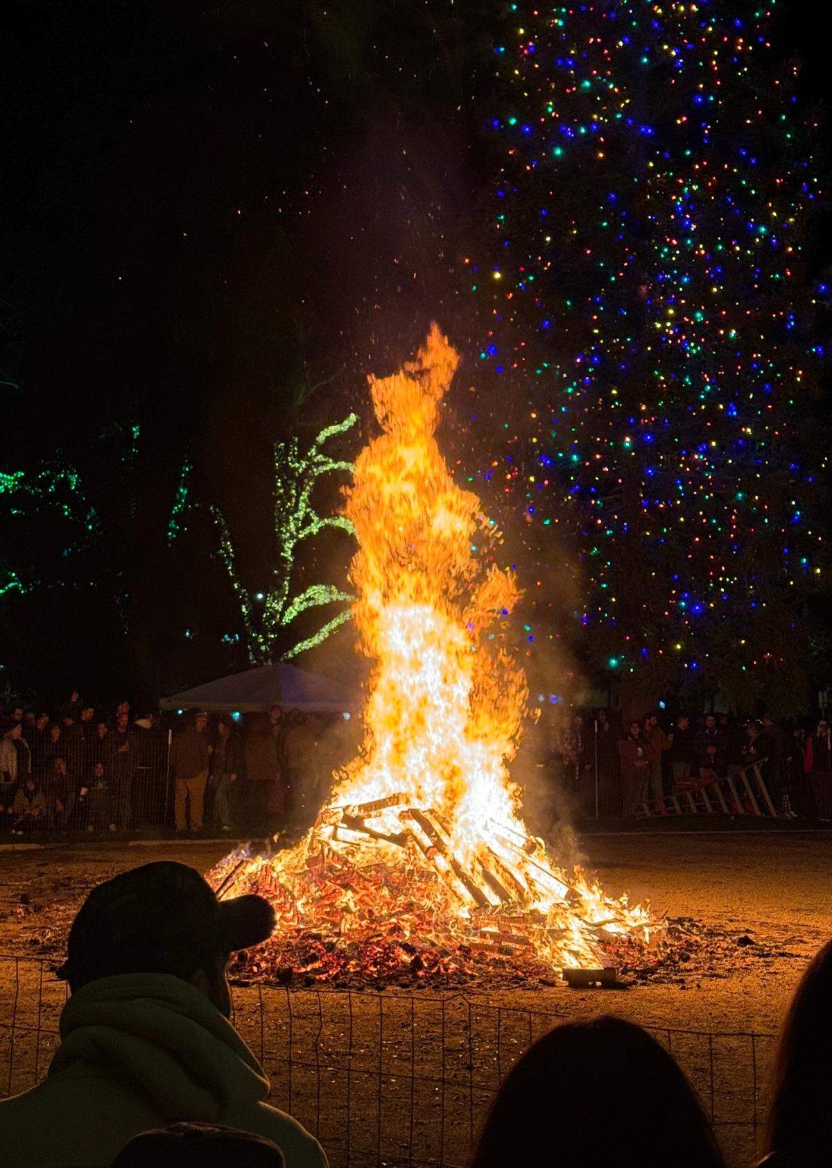 Revelers circle around the giant bonfire during Paso Robles’ New Year’s Eve celebration at the Downtown City Park on Dec. 31, 2023.
