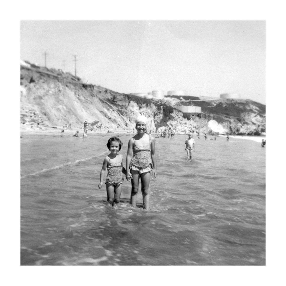 Sisters Pam Mesler (left) and Peggy Mesler waded in the surf in Avila Beach in 1958. Peggy Mesler restored the badly damaged picture at her diverse camera store, The Photo Shop in San Luis Obispo. The restored version is pictured above. 