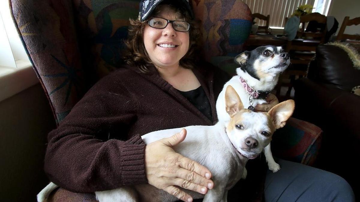 Dawn Mirabelli of Grover Beach is recovering from a cyst on her spine that temporarily paralyzed her from the waist down. Her friends are holding a fundraiser for her on Sunday. Mirabelli’s dogs Marlie Moo-moo, a rat terrier, and Jewel, a toy fox terrier, sit on her lap.