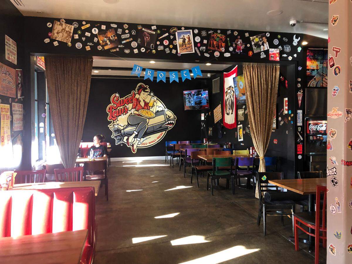 The interior dining room at Sweet Lew’s pizza restaurant in downtown Paso Robles. Customers are encouraged to add their own stickers to the eatery’s walls.