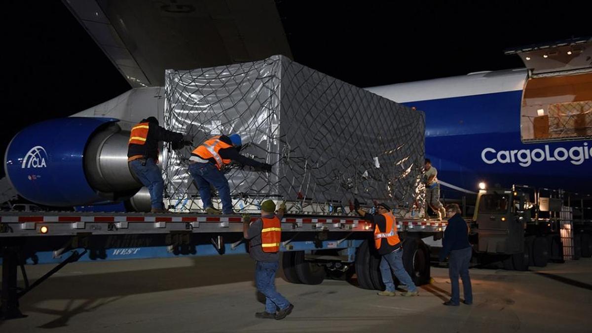 A crate containing one of the twin GRACE-FO satellites is offloaded from an cargo plane at Vandenberg Air Force Base following a transcontinental flight from Germany.
