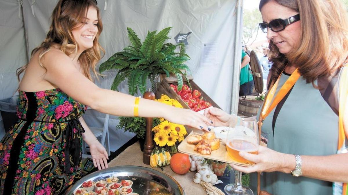 Morgan Ward, a volunteer for the Apple Farm Restaurant and Bakery in San Luis Obispo, adds a caprese salad made with heirloom tomatoes to the plate held by Melanie Cole of Merced at Savor the Central Coast on Sept. 27, 2014.