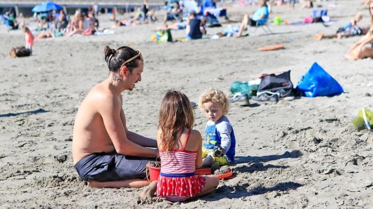 On a sunny February day at Avila Beach, Dave Fimbres plays in the sand with his children Avila, 5, center, and Rome, 3, right, all of San Luis Obispo.