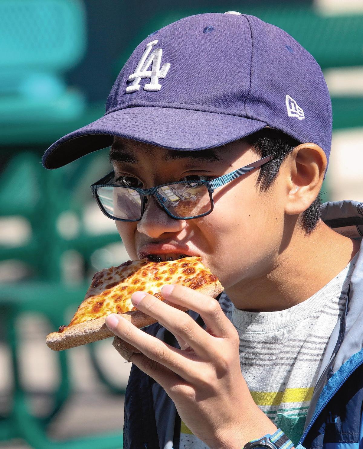 Scott “Hutch” Yoshinobu, an eighth grader at Laguna Middle School, enjoys one of the popular entrees, cheese pizza. San Luis Coastal school district works with a nonprofit called Slow Money SLO, which helps bring, healthy local food awareness in schools, while supporting the local farming community.
