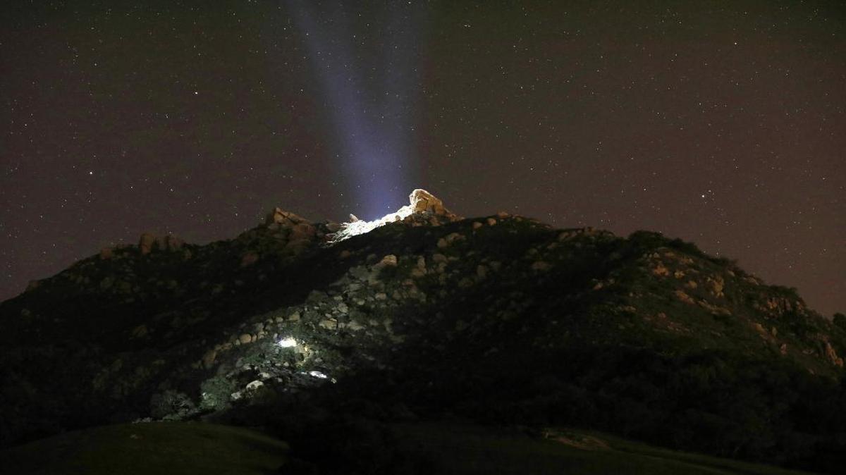 A CHP helicopter light shines on Bishop Peak as lights from a firefighter rescue crew go up the trail Thursday night, Dec. 29, 2016. Cal Fire received a report that someone had fallen near the top of the peak.