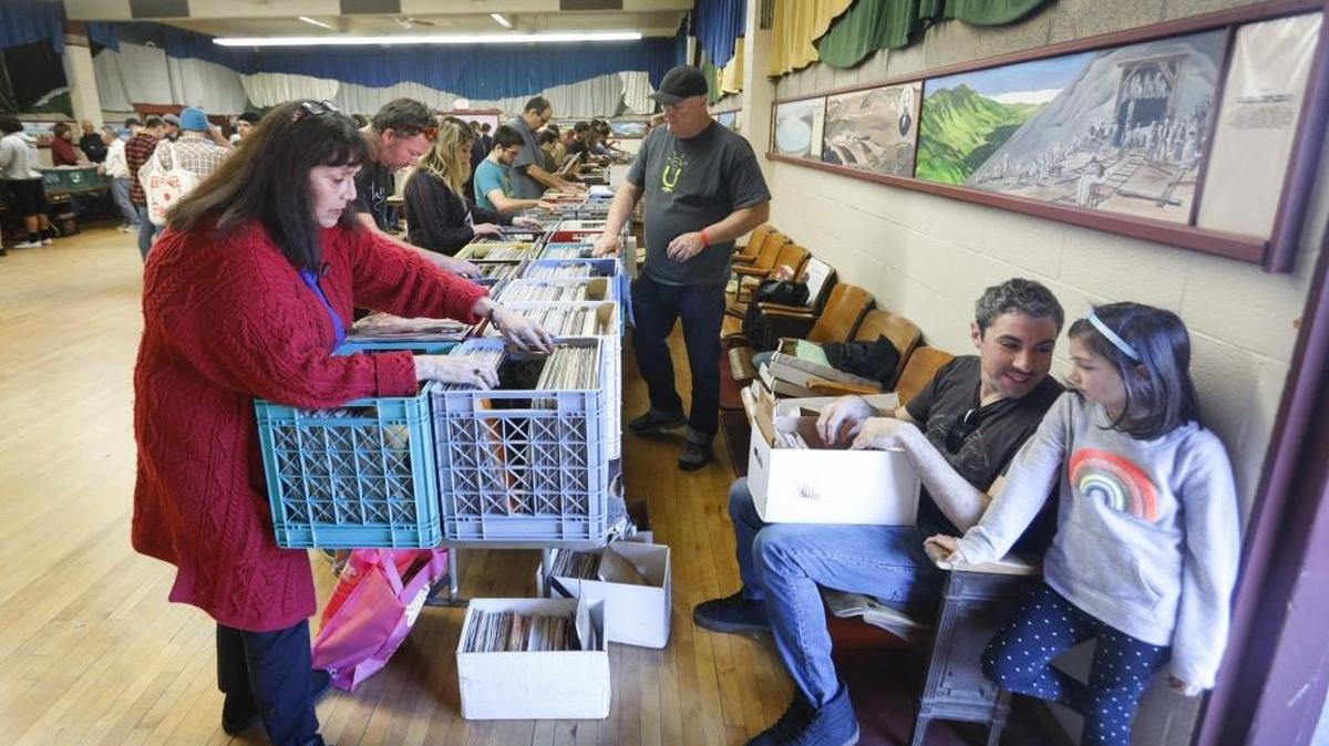 The SLO Record Swap was held Saturday at the San Luis Obispo Guild Hall in San Luis Obispo. Helen Dean, left, searches for Motown and blues records while John Carbonella and Lucy, 6, right, look at a box of 45 singles.