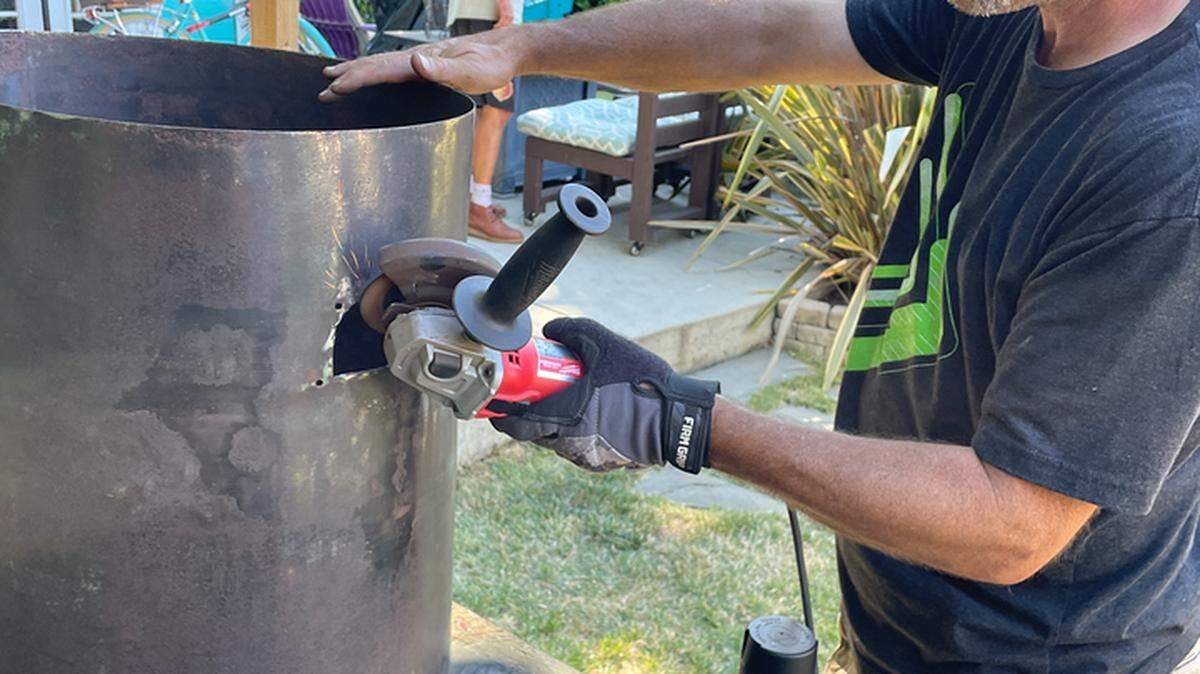 Paul Soto, a member of Cambria pioneer families, grinds rust off an 1880s stove that he and his twin brother, Brian Soto, restored and reinstalled in late October 2023 at the historical Santa Rosa School, a one-room schoolhouse that belongs to the Cambria Historical Society.
