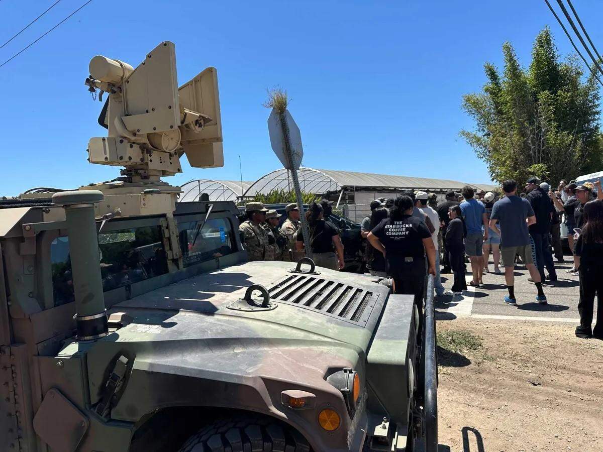A crowd confronts federal agents conducting an immigration enforcement operation at a Carpinteria cannabis farm on July 10, 2025. 