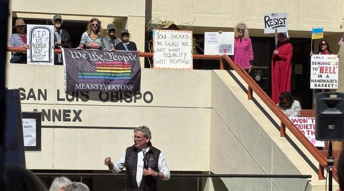 SLO County chair of the Democratic Party Tom Fulks speaks during a protest and rally recognizing International Women’s Day, outside the courthouse in San Luis Obispo on March 8, 2025.