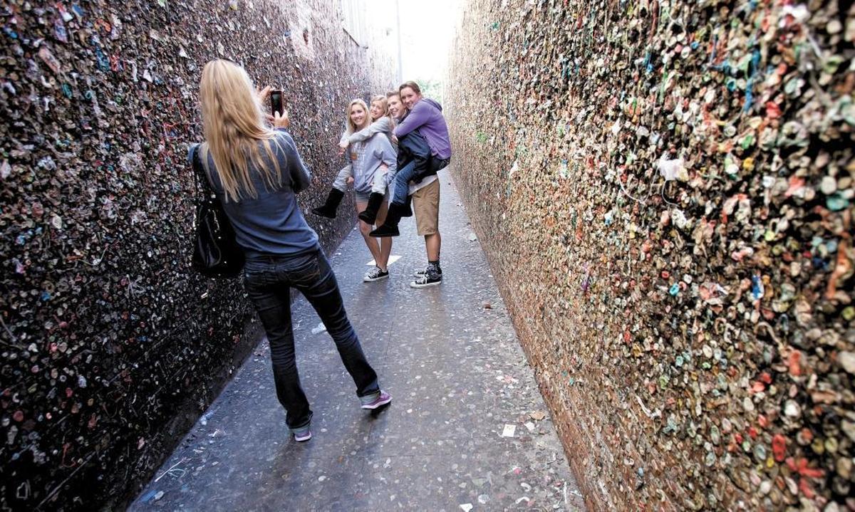 San Luis Obispo tourists take photos of themselves in Bubble Gum Alley.
