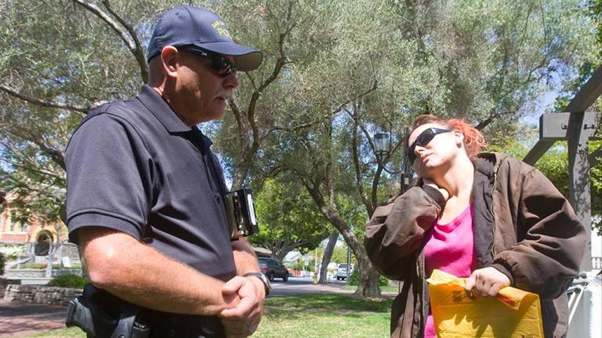 Former San Luis Obispo Police Officer Jim Fellows, then a member of the department’s Community Action Team, talks to Jessica Patterson near the Murray Adobe in Mission Plaza in August 2013.