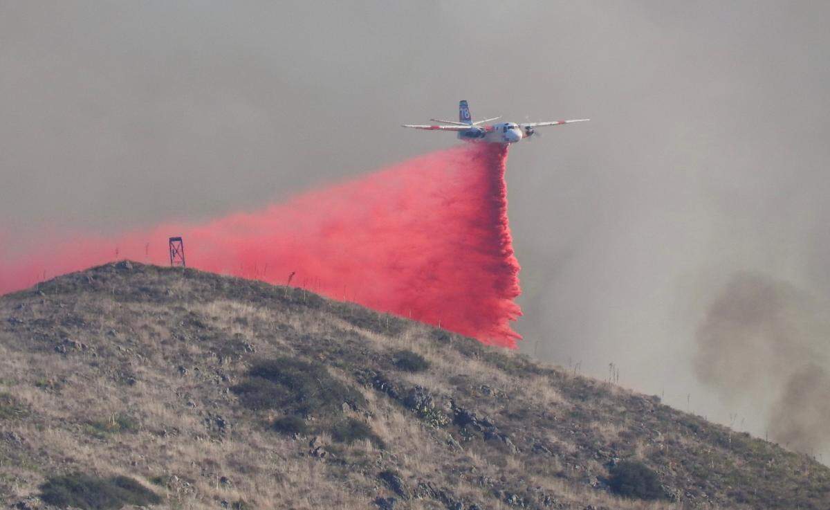An air tanker drops retardant on a fire burning in the hills behind San Luis Obispo High School on Monday, Oct. 30, 2023.