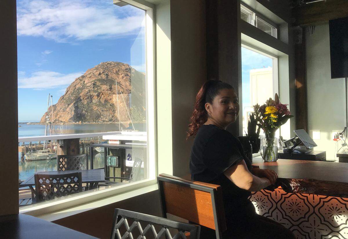 Lucy Robinson perches at the Morro Grill bar. The dining room and outdoor deck of the new eatery on the Embarcadero overlook Morro Rock and the bay.