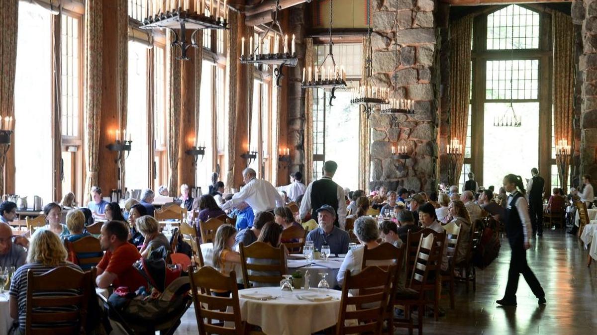 In this 2014 photo, diners eat lunch in the historic Ahwahnee Hotel in Yosemite. The names of iconic hotels and other facilities in the world-famous Yosemite National Park will soon change in an ongoing battle over who owns the intellectual property, park officials said Thursday. The famed Ahwahnee Hotel will become the Majestic Yosemite Hotel, and Curry Village will become Half Dome Village, park spokesman Scott Gediman said.