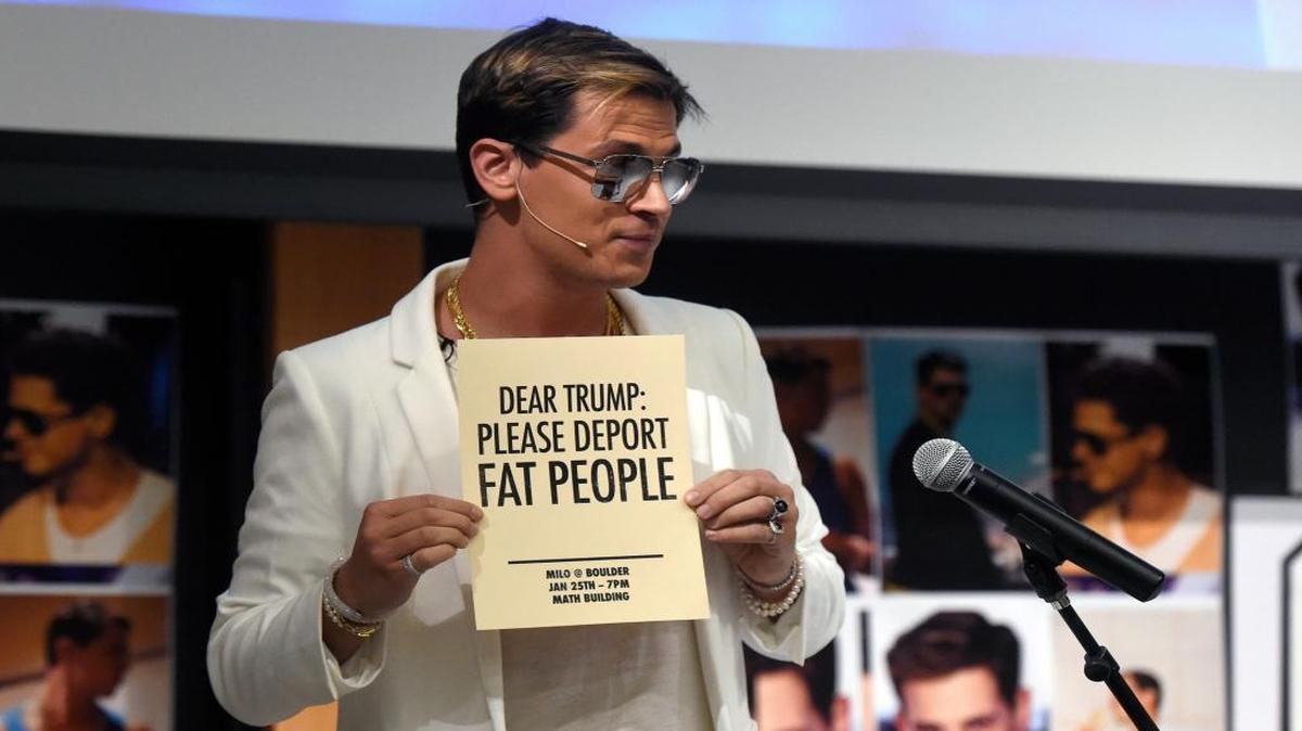 Milo Yiannopoulos holds a sign as he speaks at the University of Colorado campus in Boulder, Colo., on Wednesday.