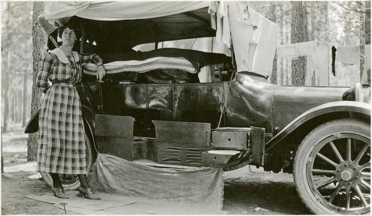 In a photo from 1920 Grace McCarthy stands next to the couple’s car outfitted for camping with a mattress on top of the seats and a tarp over the windows for privacy.