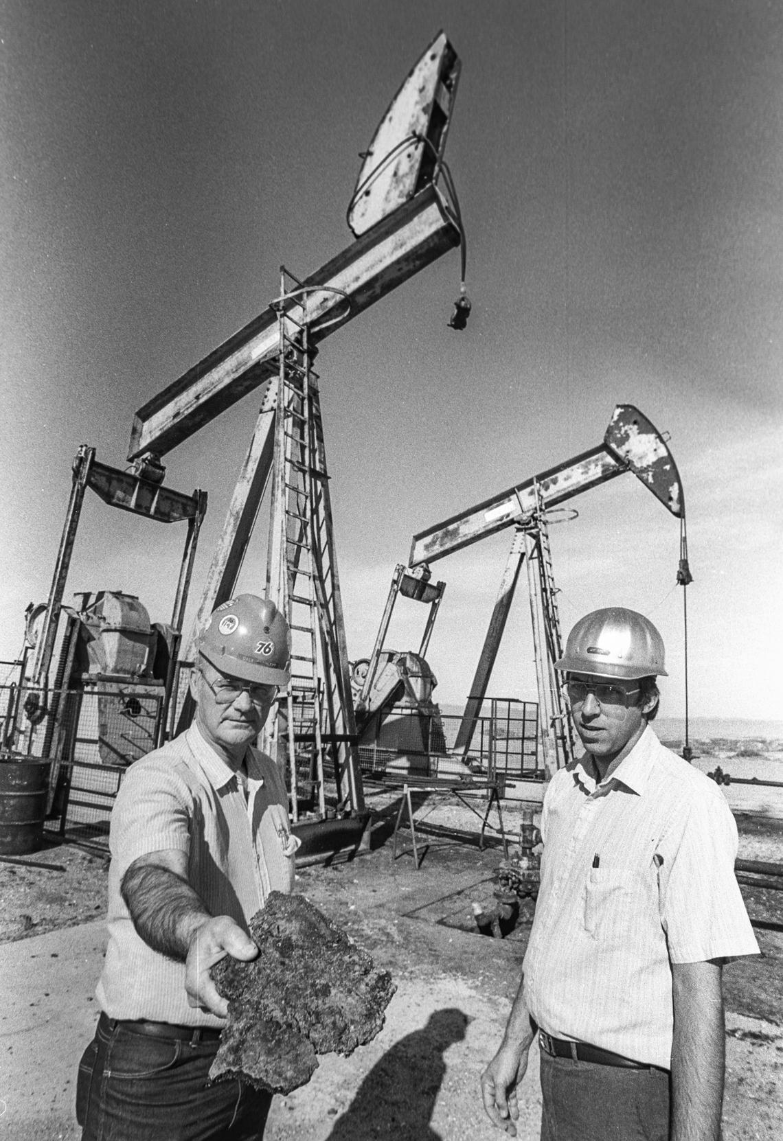 Unocal’s Dale Elchlepp, left, shows a solid example of his company’s product during a tour of a Unocal (formerly Union Oil) oil field in the Guadalupe Dunes in 1989. At right is Jim Shew. The field was shut down in 1994 because a chemical used to help extract the asphalt-like oil product was contaminating nearby areas.