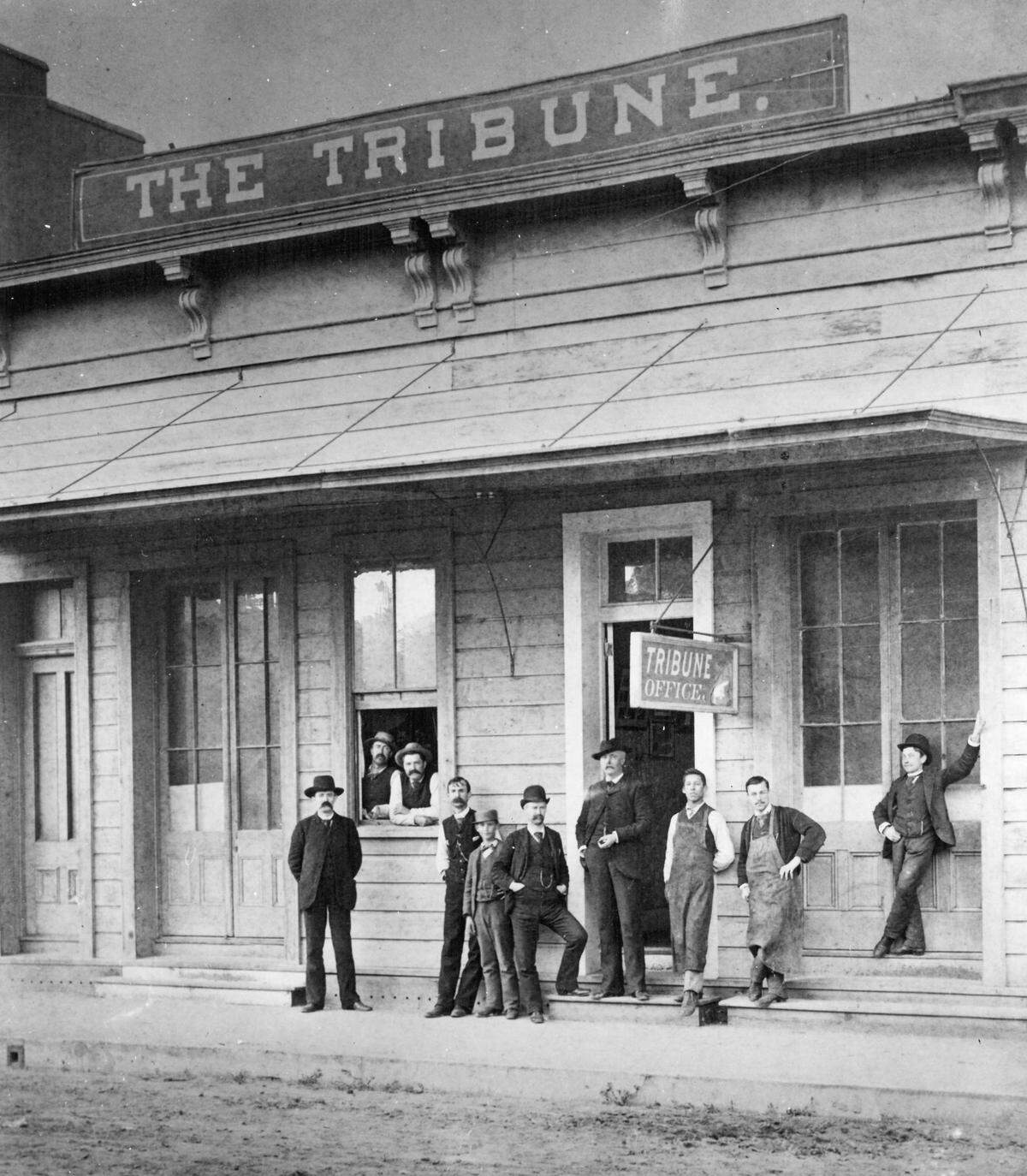 When a mechanized upstairs press upset patrons of the bar downstairs, Benjamin Brooks moved the sign and Tribune offices to a ground floor facility on Chorro Street, where the newspaper operated from the late 1800s to about 1925. Brooks is the man in the doorway, with printers in smocks at the right.