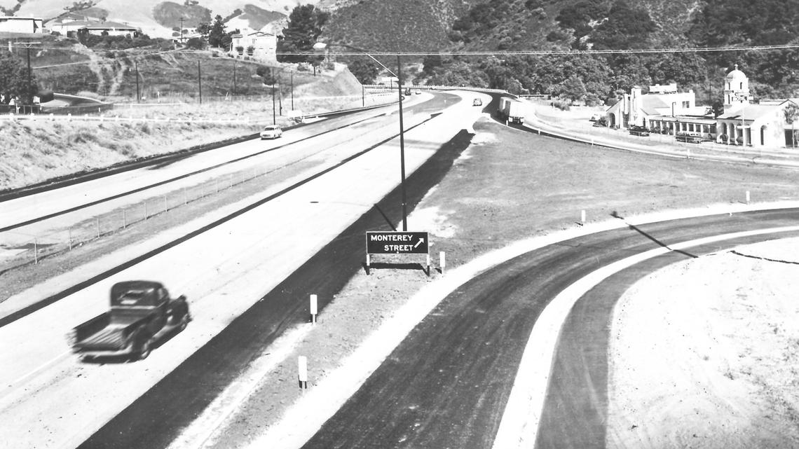 A photo shows northbound Highway 101 in San Luis Obispo, with the Monterey Street exit, Motel Inn and Cuesta Grade in the background, circa 1960.