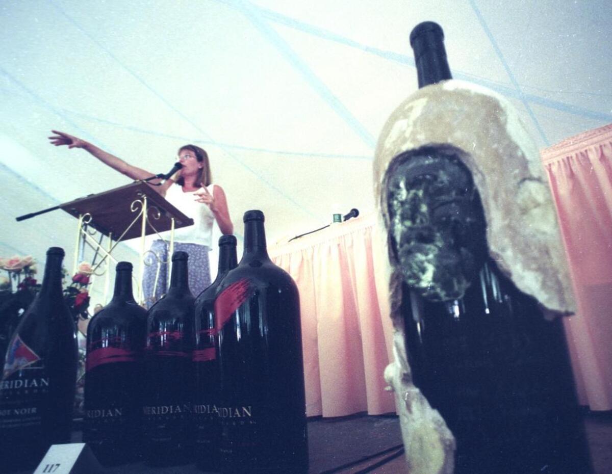 Ursula Hermacinski calls for bidders during the KCBX wine auction on July 12, 1997. Saturday. The wine bottle in the foreground is an Adelaida Cellers 1993 Cabernet Sauvignon magnum.