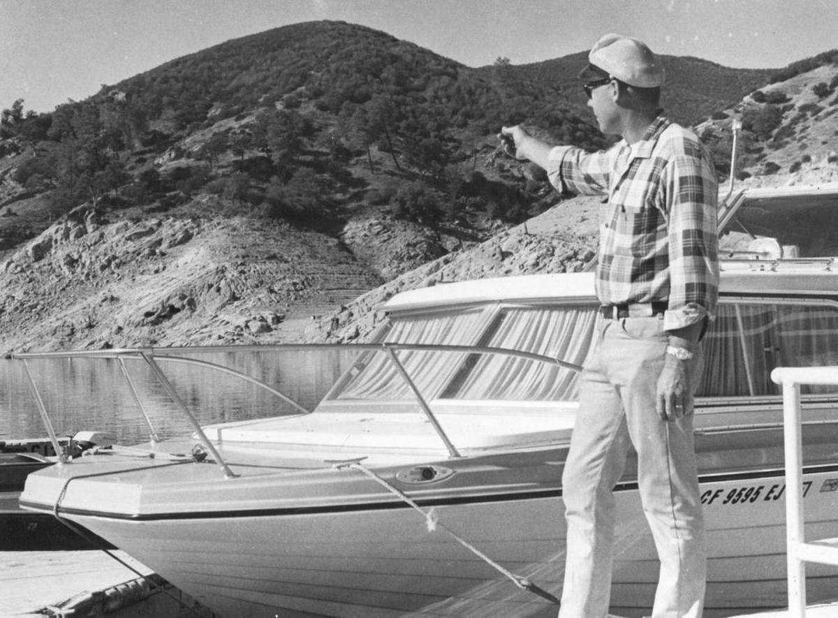 Dick Kelsey, manager of Lake Nacimiento Park, points to the high-water level on the hillside 80 feet above the marina where he is standing.