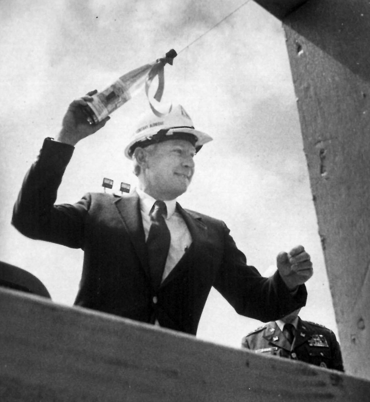 Air Force Undersecretary Edward C. Aldridge Jr. swings a bottle of California wine toward the Vandenberg Air Force Base shuttle launch pad during dedication in May 1984.
