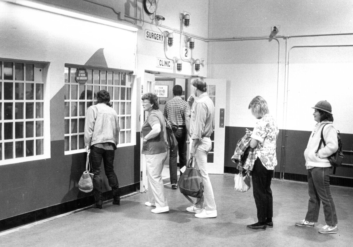 Psychiatric technician Tracy Jensen, at right, waits with other employees to be checked through the security gate. Atascadero State Hospital was the world’s largest hospital for the criminally insane in 1987.