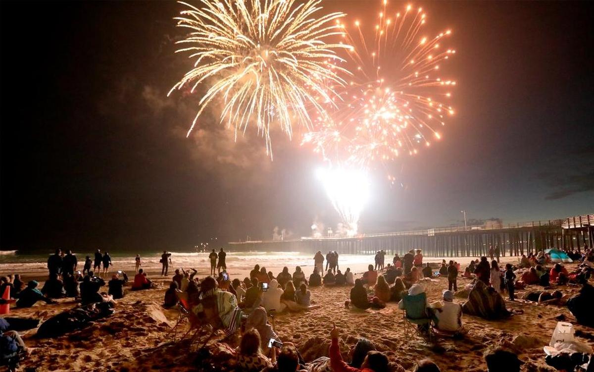Beachgoers watch the Pismo Beach fireworks show in 2017. Pyrotechnics will return to the Pismo Beach Pier on Monday, July 4, 2022.