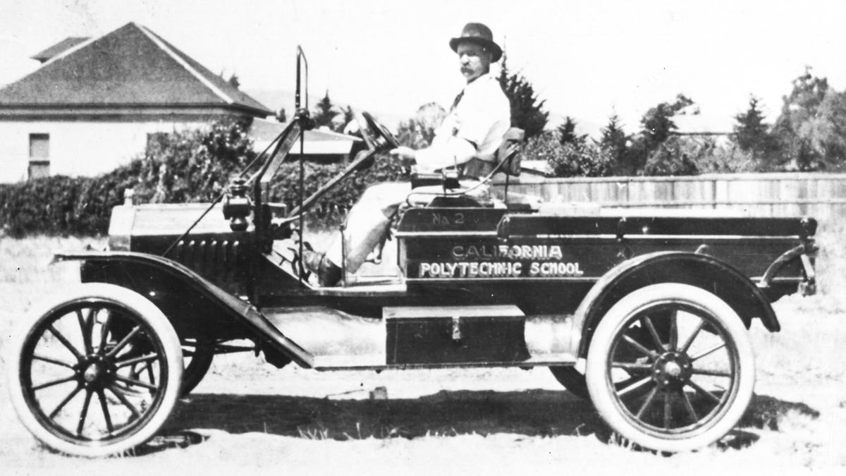 George L. Drummond poses for a picture at the wheel of a 1915 pickup truck. It is described as the first motorized vehicle (though it is marked 2) owned and operated by Cal Poly.