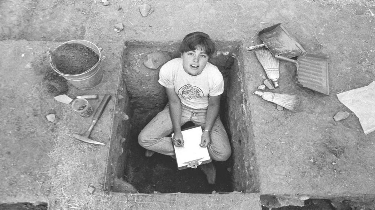 Heather Cooper, surrounded by her tools, looks up from her work in a pit dug at former site of mission soldiers' barracks at Mission San Antonio de Padua.