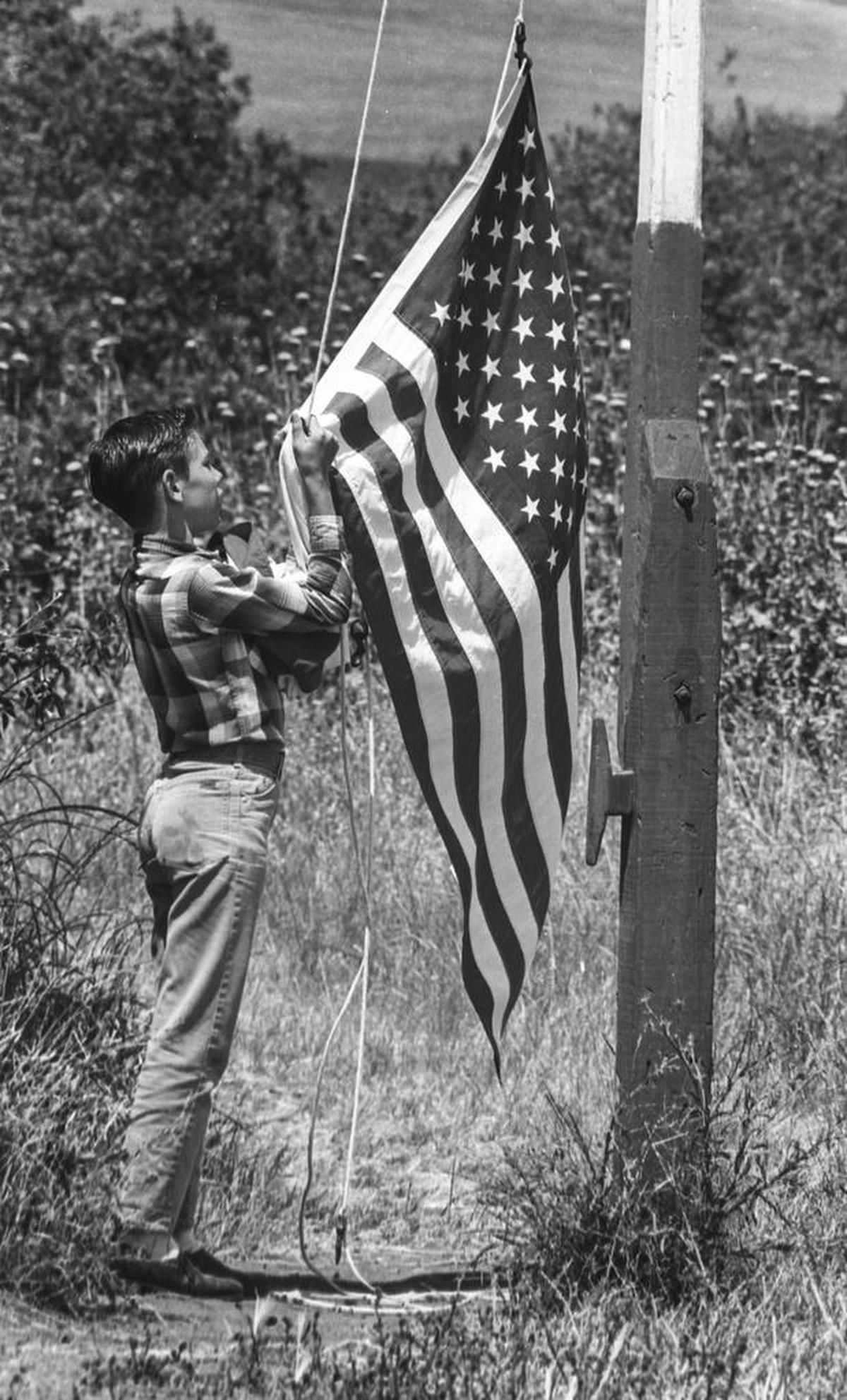 Russell Mendes pulls down the flag on the last day of school at Banning, a one-room schoolhouse east of Morro Bay.