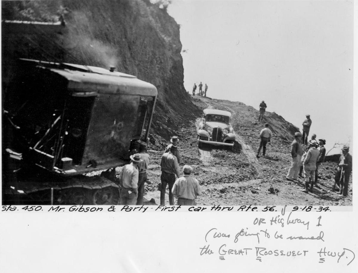 A photo from Sept. 18, 1934, shows Highway 1 under construction before it was paved and opened to public traffic. A hand-written caption says: “Mr. Gibson & party, first car thru Rte 56 or Highway 1. Was going to be named the Great Roosevelt Highway.”