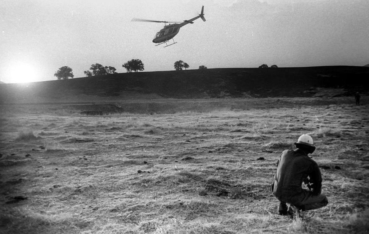 Forest Service firefighter Charlie Roberson watches as a helicopter carries away the bodies of three firefighters killed during brush fire east of Nipomo on Highway 166.