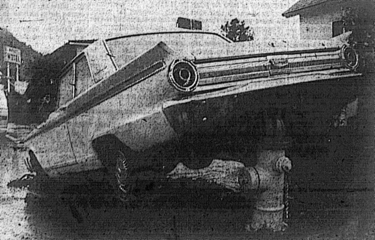 Car lands in an awkward position on Marsh near Higuera Streets. January 1973 flooding damaged up to 100 cars in San Luis Obispo.