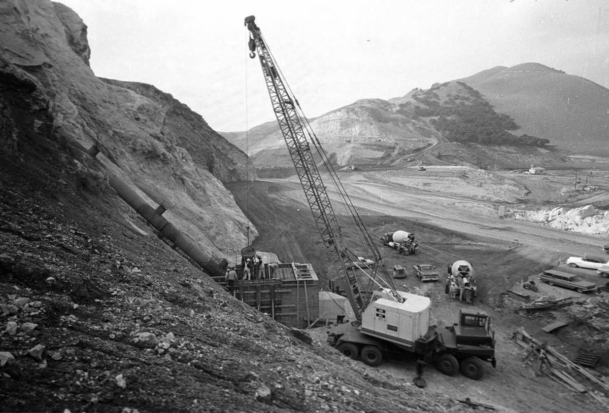 An intake pipe, left, rises behind Lopez Dam during its construction in 1968.