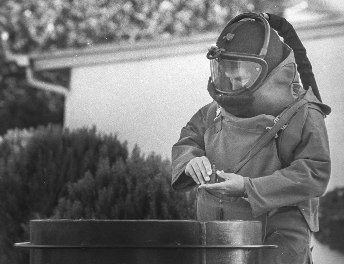 Jerry Lenthall places a World War II mine into a container on the bomb squad's trailer. Two live German anti-personnel land mines were taken to the San Luis Obispo Police Department rifle range and detonated.