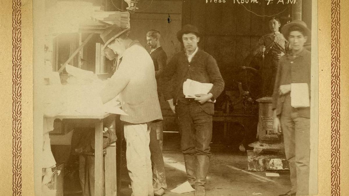 Benjamin Brooks was editor of the San Luis Obispo Morning Tribune for 4 decades. He is standing center in profile, back wall and appears to be final proofing at 4 A.M. for the morning paper. This is from a series of newspaper carrier postcards from 1890.