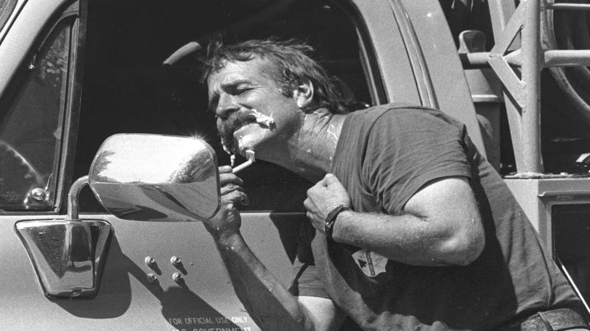 Mark Linane of the U.S. Forest Service shaves after taking a four-hour rest period while fighting the Hi Mountain Fire in July 1988.