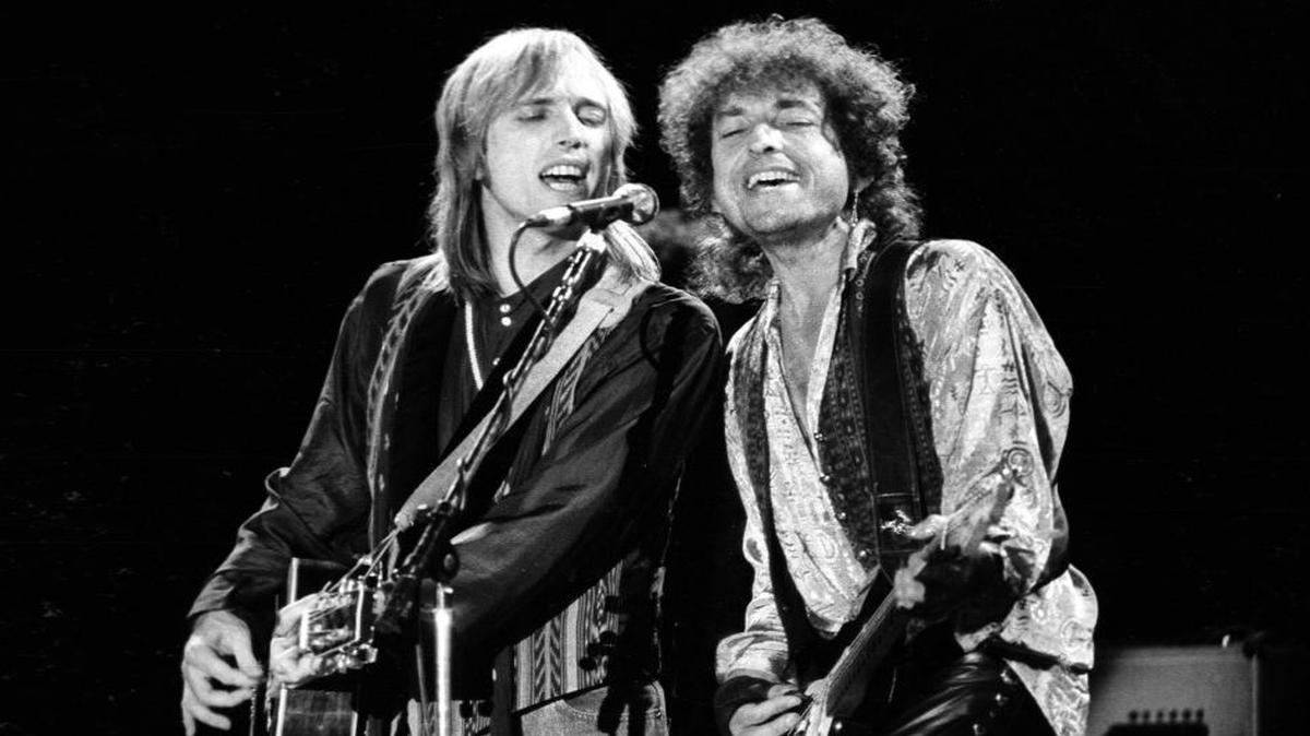 Tom Petty, left, and Bob Dylan sing harmony during the last night of the True Confessions tour at the Mid-State Fair in Paso Robles in 1986.