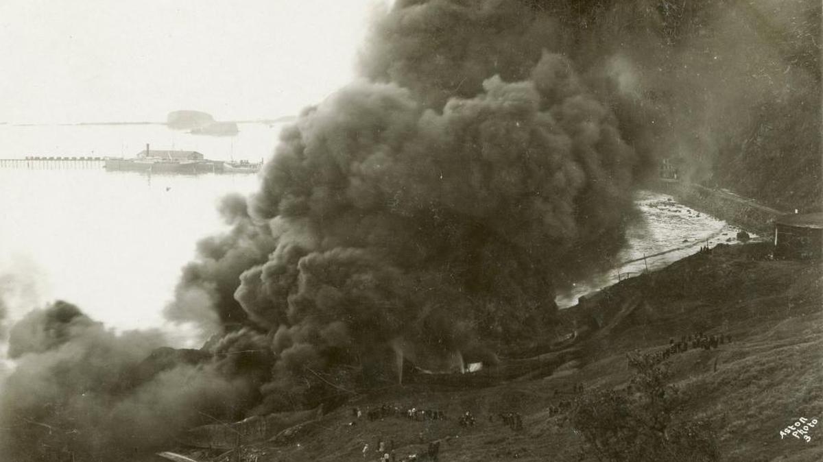 Dozens of spectators watch efforts to contain a fire at the Union Oil tank farm in Avila Beach in January 1908.