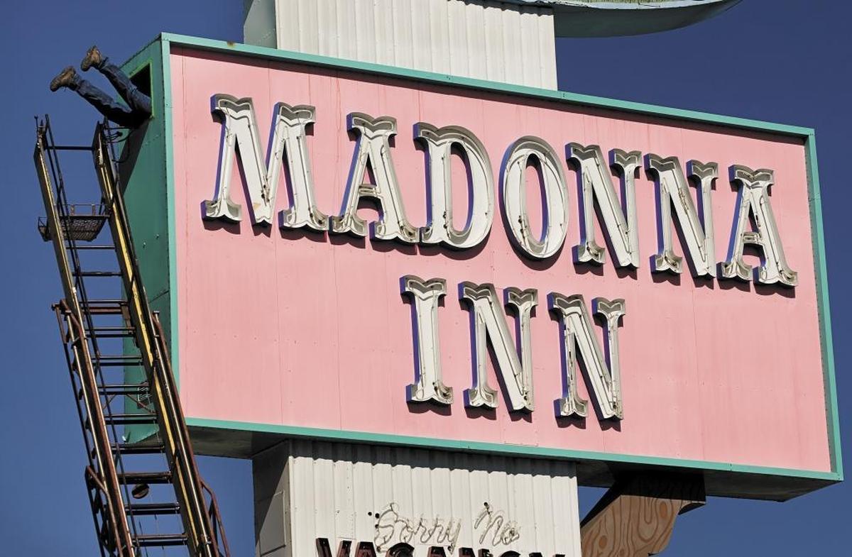 Larry Desario, owner of Santa Maria Neon Electric Signs, crawls into the Madonna Inn sign to repair the Madonna part of the neon lettering which was on the blink because of water damage in 2013. The sign has survived even as others were dismantled.