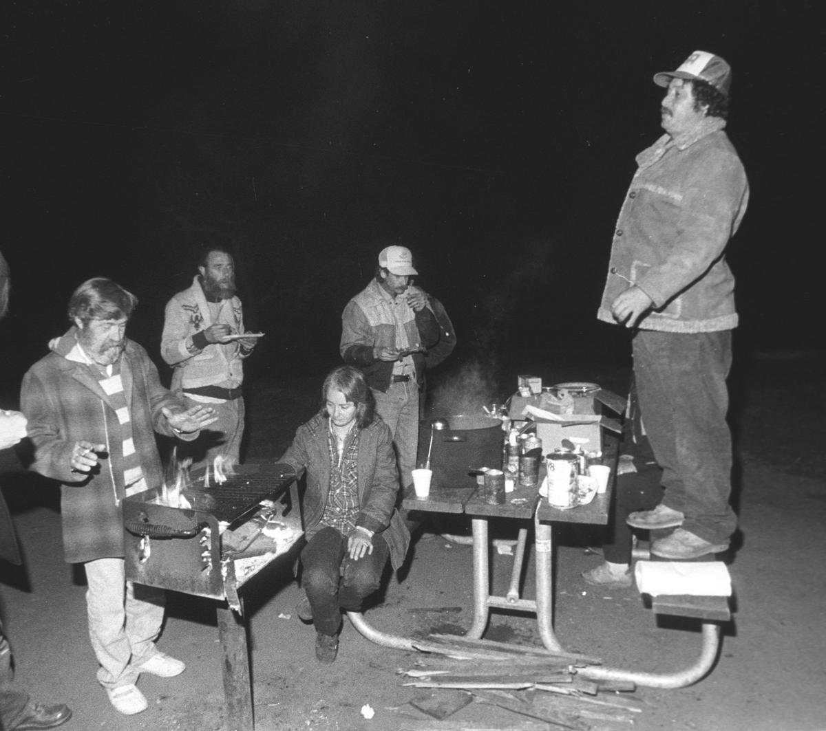 Stuart Meeks stands on a picnic table to pay tribute to efforts of Brad Goans to keep the Zedakah House bus shelter going in 1988.