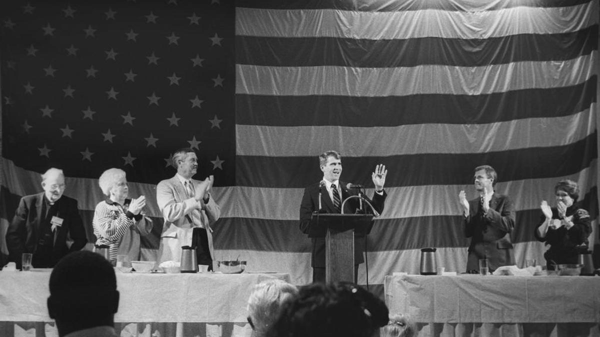 Oliver North receives warm applause while at the lectern in Santa Maria during a visit in 1988. Eric and Andrea Seastrand at the right. Over 800 supporters attended the fundraising dinner while about 300 protesters carried placards outside.