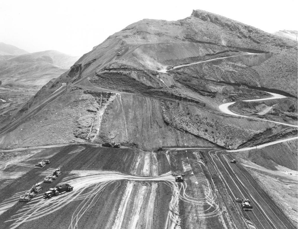 Earth-moving equipment hauls dirt to build the earth fill Whale Rock dam.