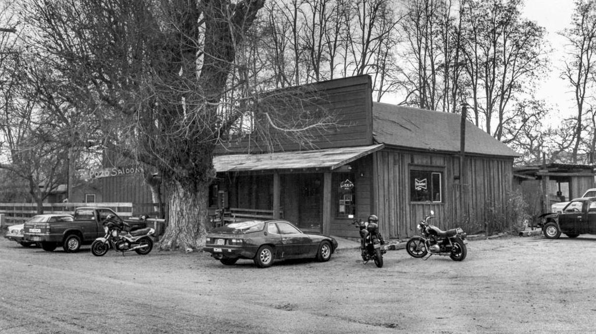 A huge cottonwood tree dwarfs the Pozo Saloon, where porsches and BMWs compete with cowpokes' trucks in a 1987 photo.