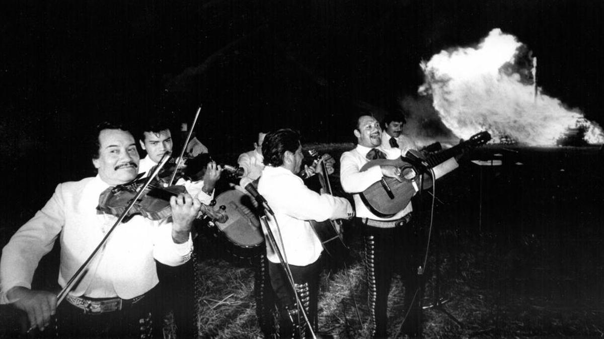 A mariachi band plays at the kick off to the 1989 La Fiesta as the bonfire of Zozobra, Old Man Gloom, lights up the background near the Elks Club Lodge.