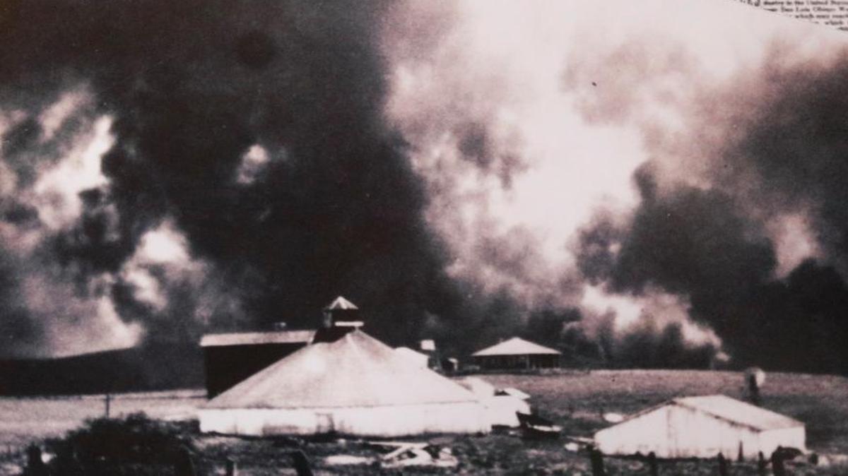 A historic photo from April 1, 1926, shows smoke from the Tank Farm fire billowing behind the Octagon Barn. The photo was taken by Thelma Irene Waldrum, who was 16 years old at the time.