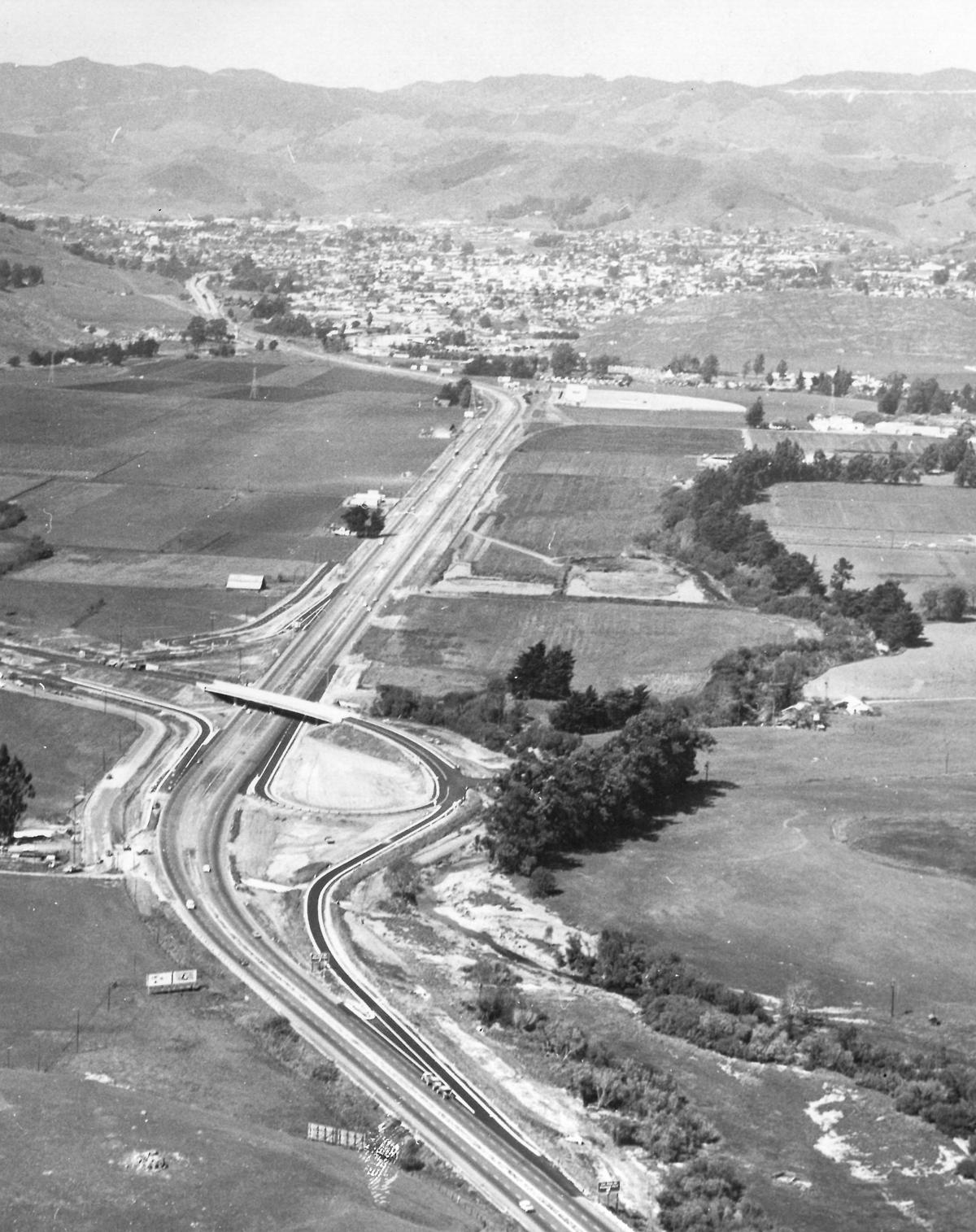 Aerial view of Highway 101 dated April 1962. Los Osos Valley Road overcrossing is under construction. The connection to Los Osos Valley Road would be decades in the future, the sewer plant and Madonna Plaza had not been built.